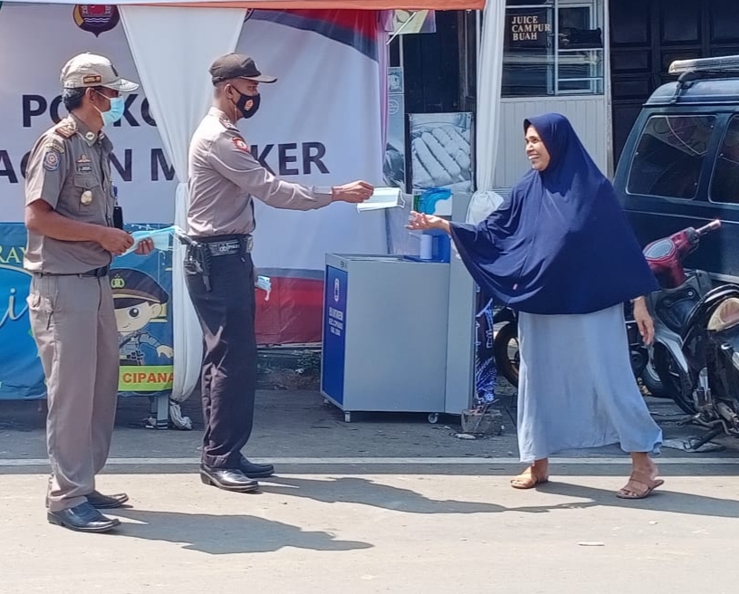 Polsek Cipanas Polres Lebak membagikan masker kepada para pengunjung pasar Gajrug (Poskota.net/Dok Ist)