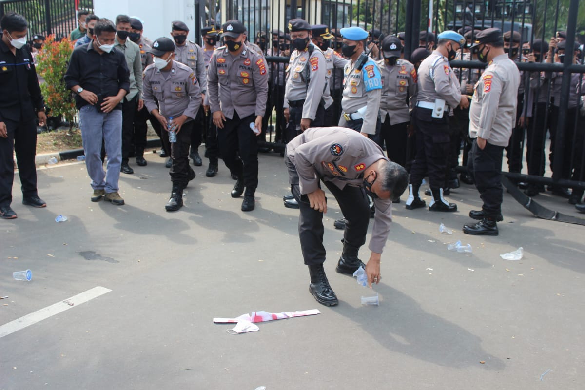 Kabid Humas Polda Banten beserta personel Polda Banten melakukan bersih-bersih sampah pasca aksi unjuk rasa (Poskota.net/Dok Ist)