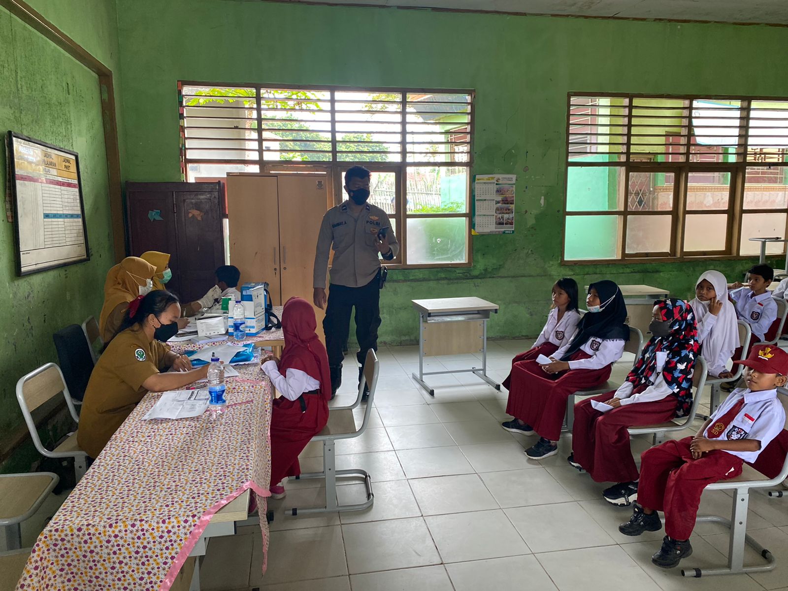 Aipda Rahmat Hidayat Bhabinkamtibmas Polsek Kronjo Pantau Pelaksanaan Vaksin Di SDN Gandaria