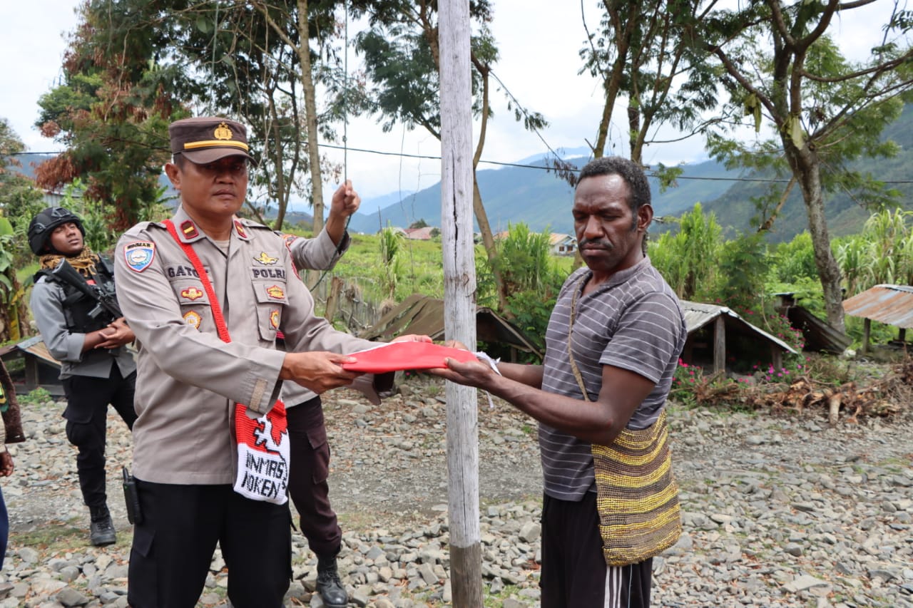 Sat Binmas Polres Puncak Jaya Kembali Bagikan Bendera Merah Putih Kepada Masyarakat Kota Mulia