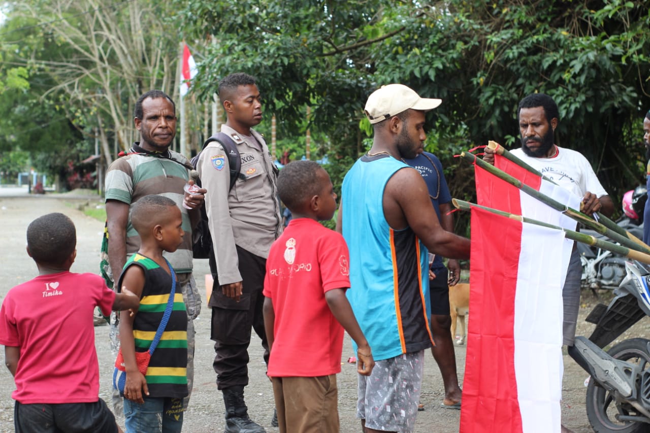 Bhabinkamtibmas Polres Mimika Ajak Masyarakat Desa Binaannya Kibarkan Bendera Merah Putih