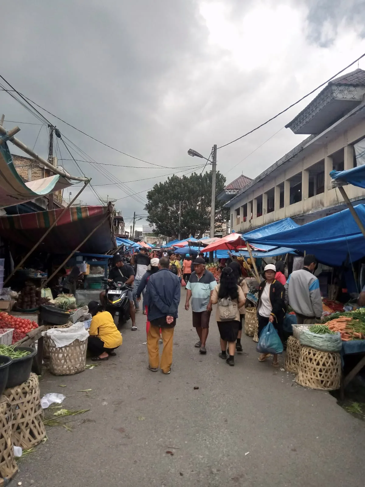 Pasar  Tiga Raya Kecamatan Raya Tetap Ramai Dikunjungi Meskipun Turun Hujan