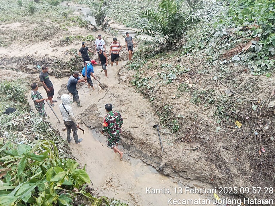 Babinsa Tiga Balata Gotong Royong Bersama Masyarakat untuk Bersihkan Gorong-Gorong yang Tertutup Kayu Penyebab Banjir