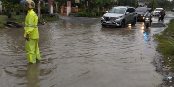 Hujan Deras Genangi Jalan KM 35! Dua Personil Polsek Perdagangan Siaga di Tengah Banjir Atur Lalin